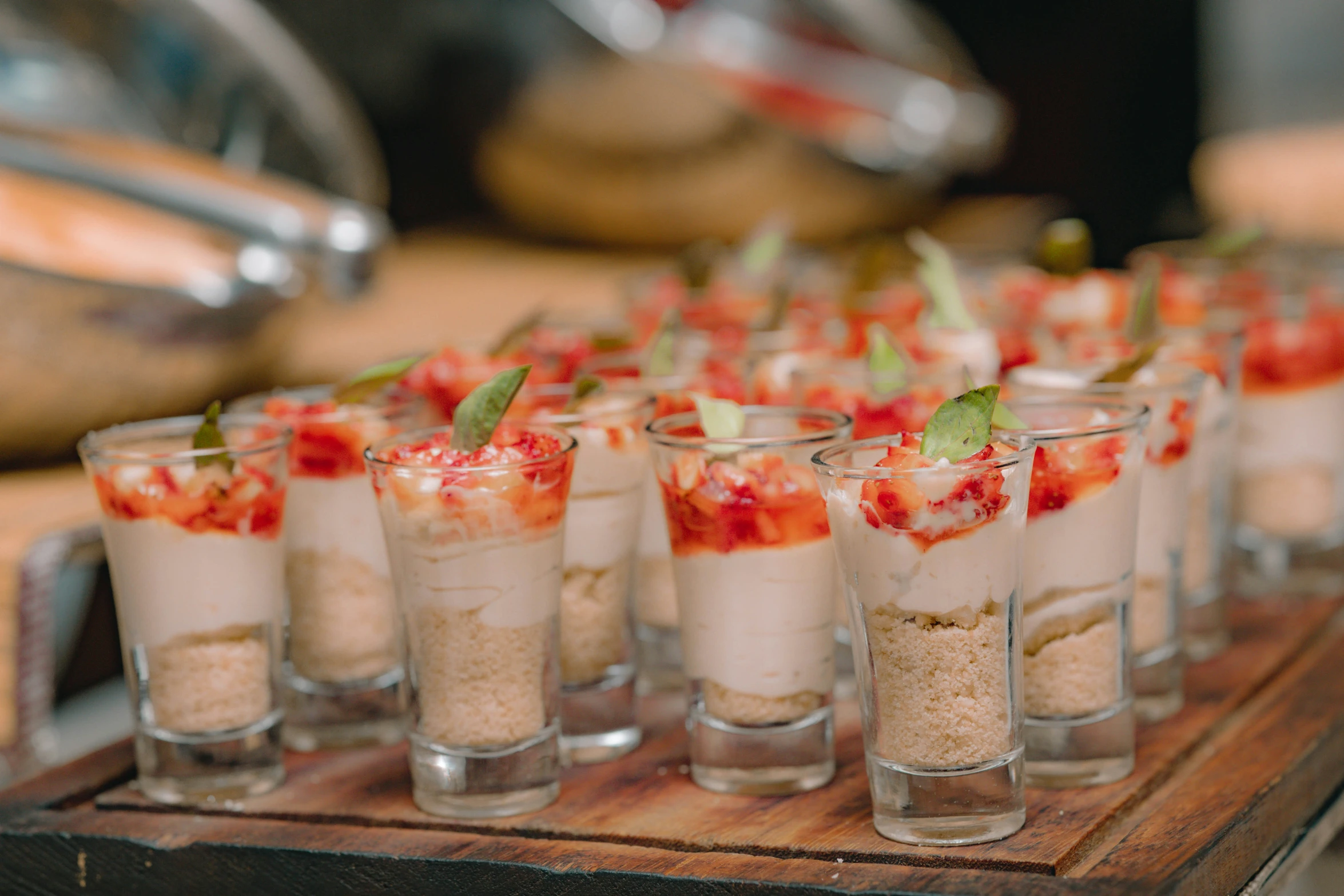 small dishes are lined up on a wooden tray