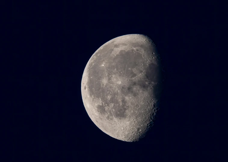 a large moon on a dark background with a few lights