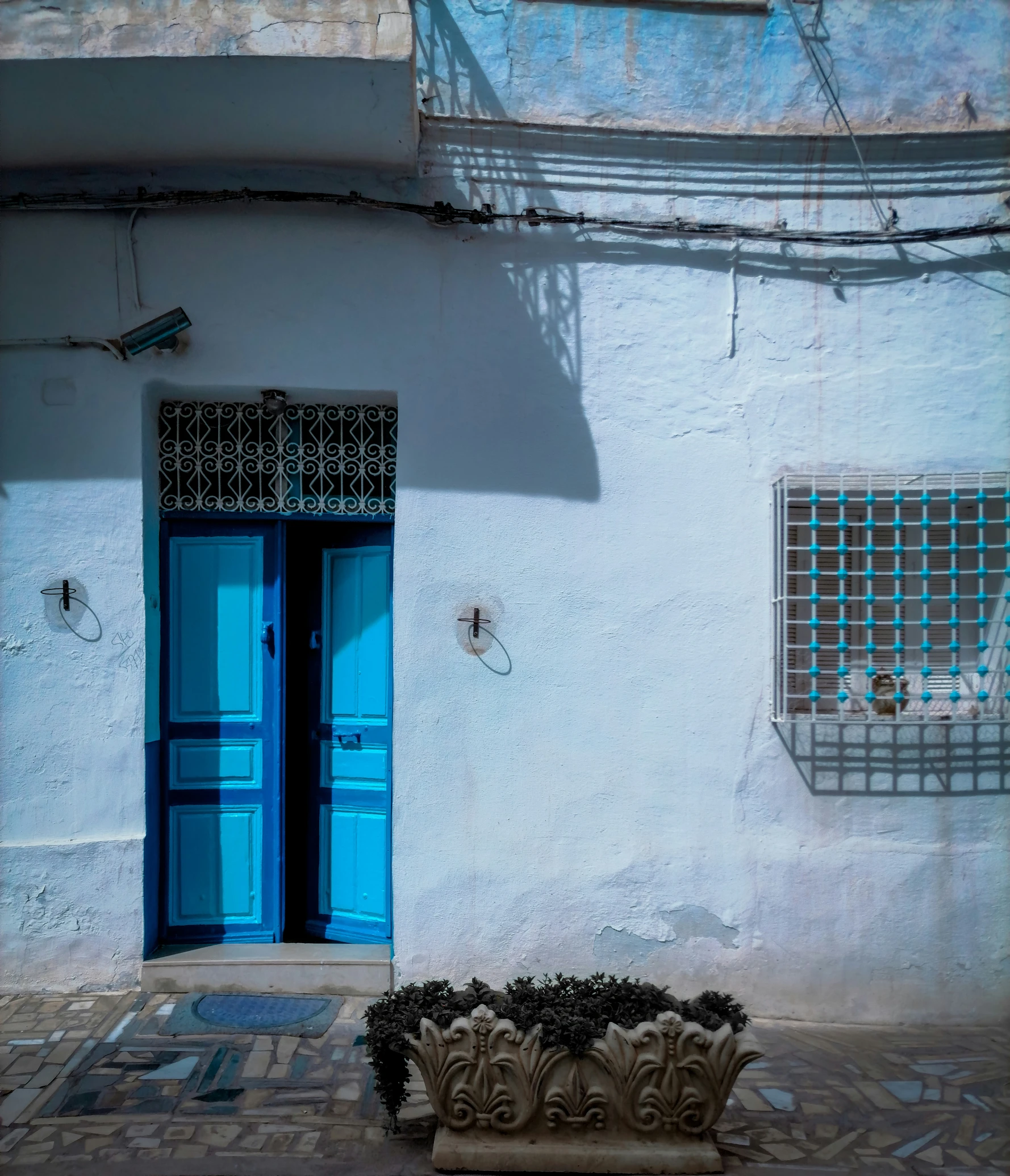 a white building with two blue doors and windows