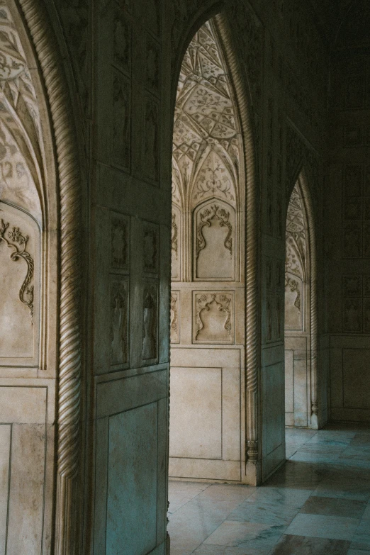 an open corridor with arches and benches and a bench