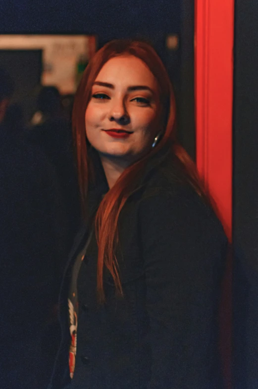 a beautiful young woman standing next to a wall