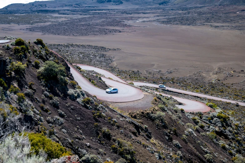 a car traveling down a winding dirt road