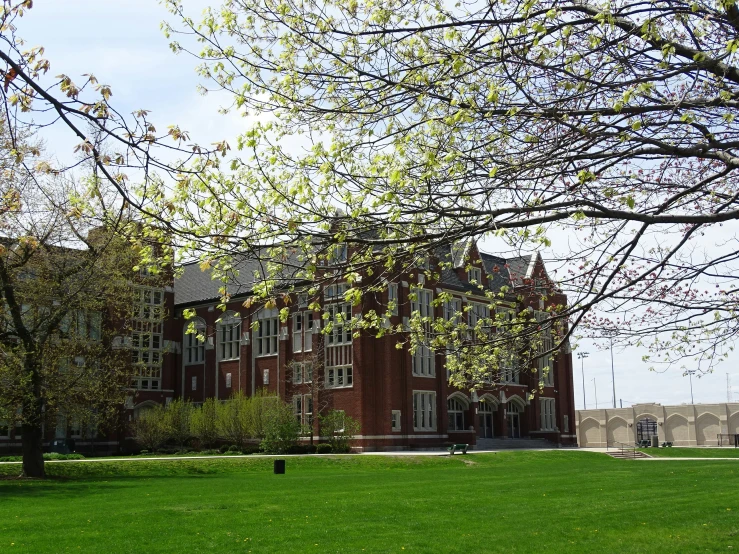 an old red building in the middle of a green field