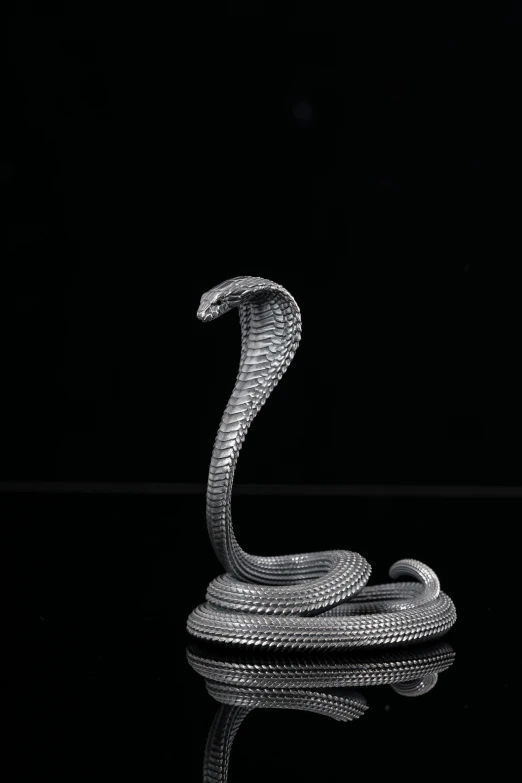 a metal snake sculpture that is on a table