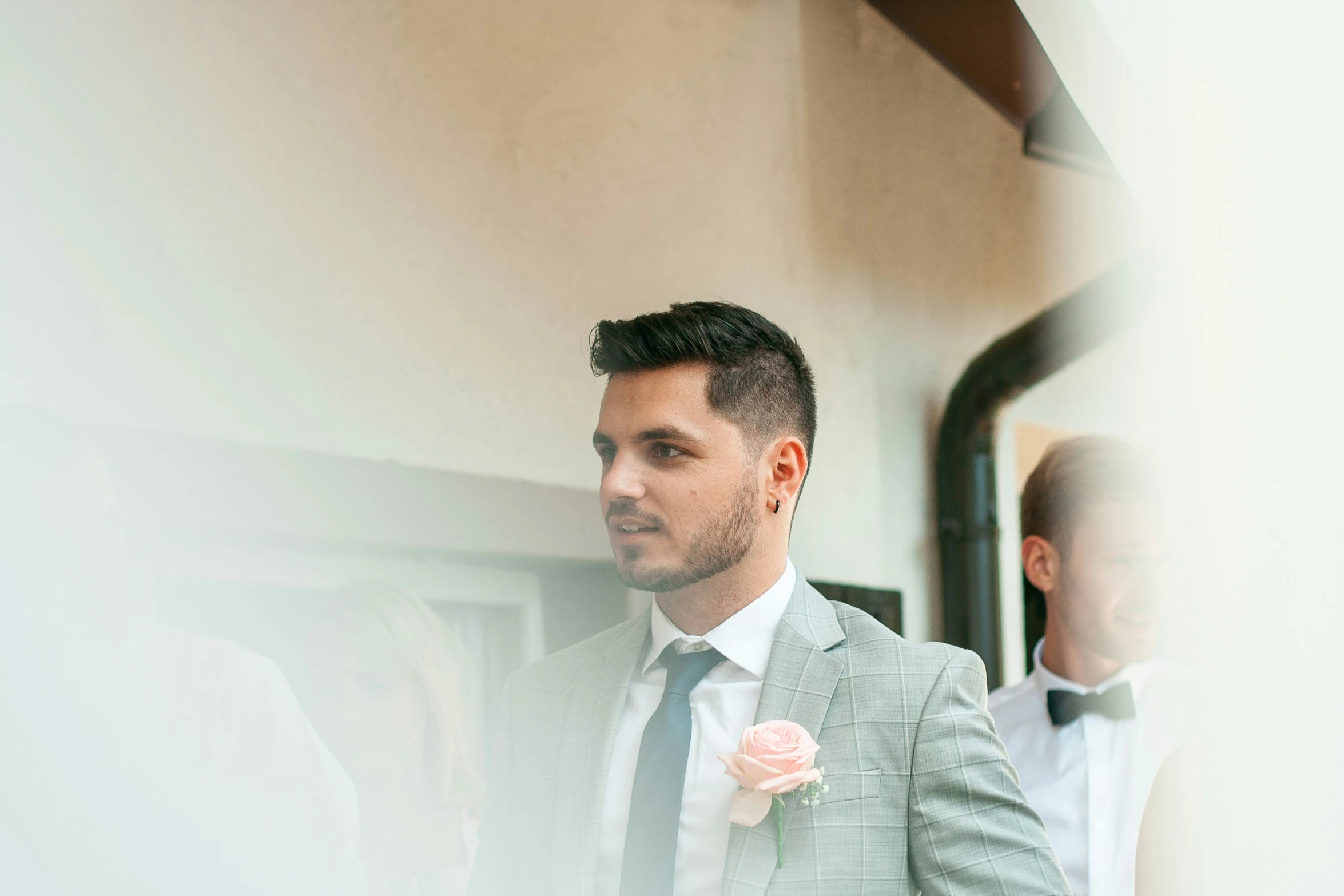 a man standing next to another man in front of a mirror