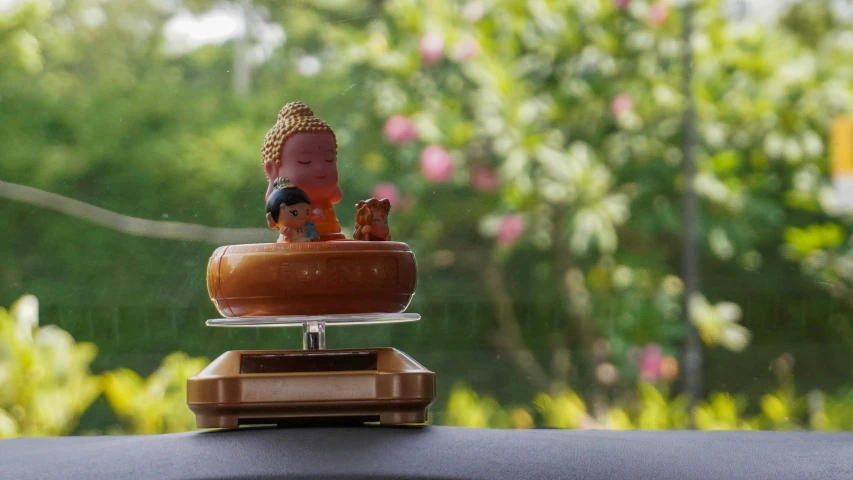 a statue of buddha in the top of a cake on top of other decorations