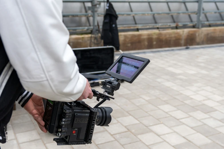 a person holding a camera with other people in the background