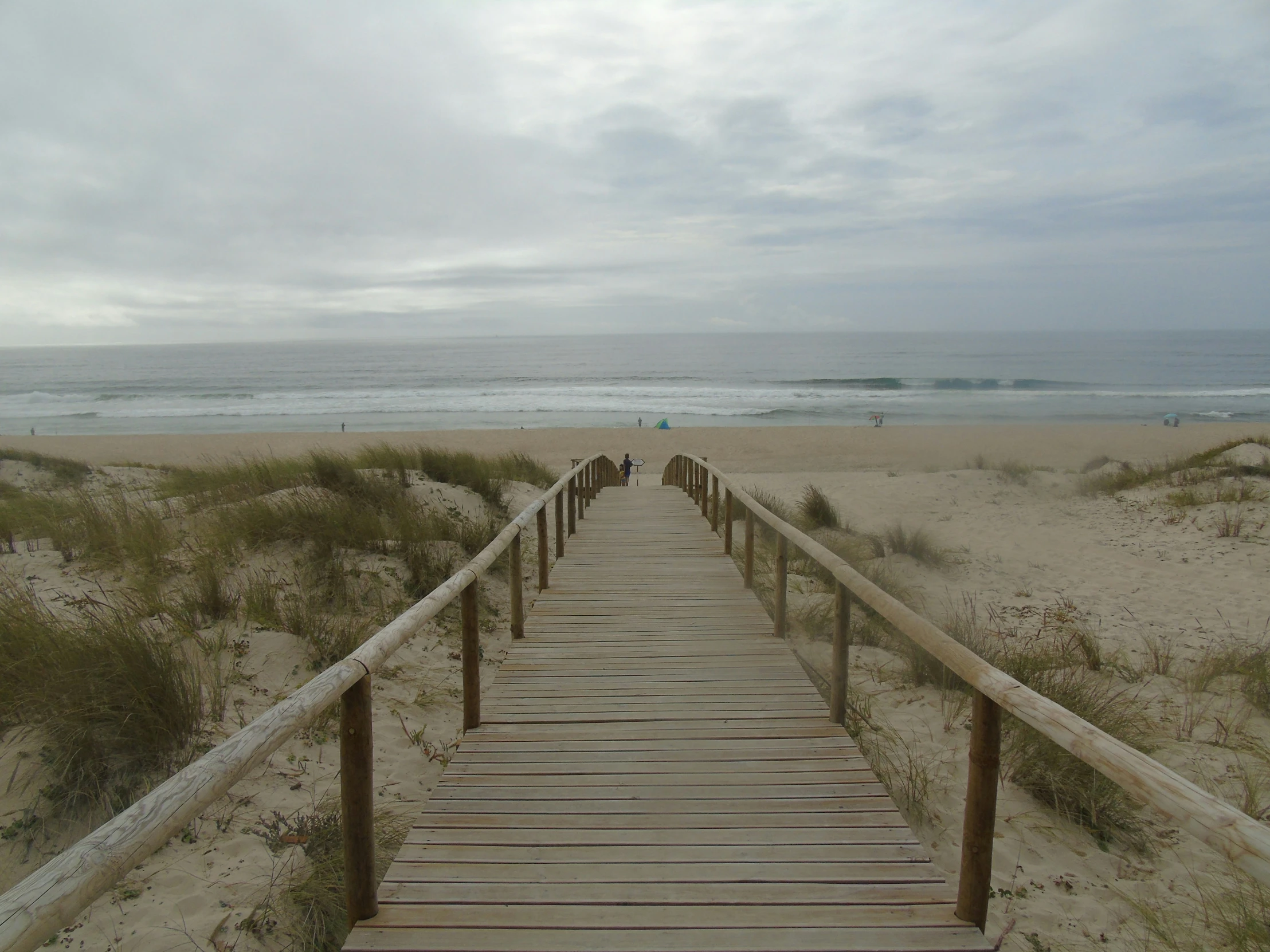 wooden walkway leading to the beach with waves coming in