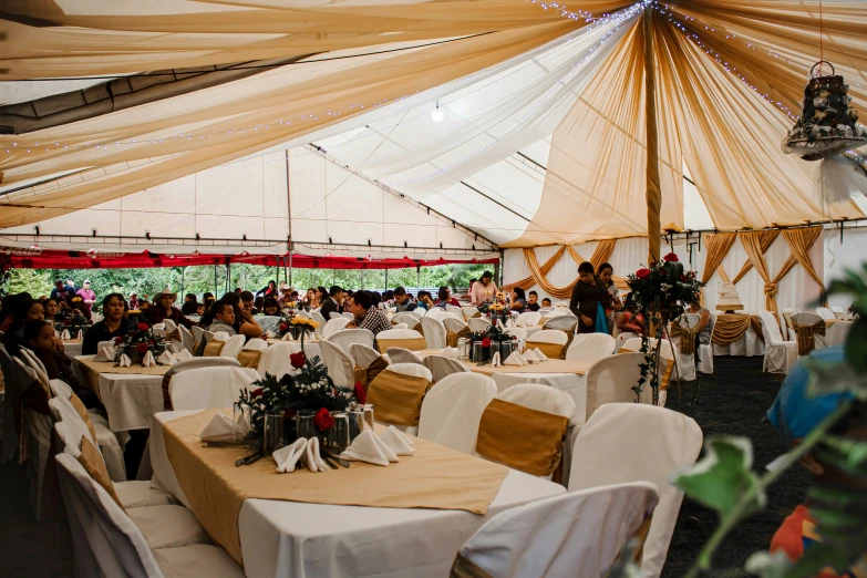 the interior of an outdoor tent filled with tables and chairs