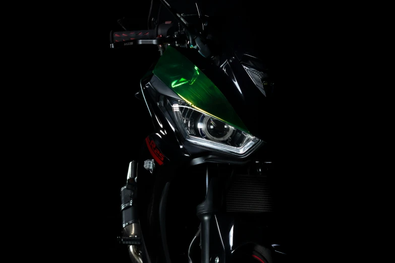 front view of green motorcycle parked in dark area