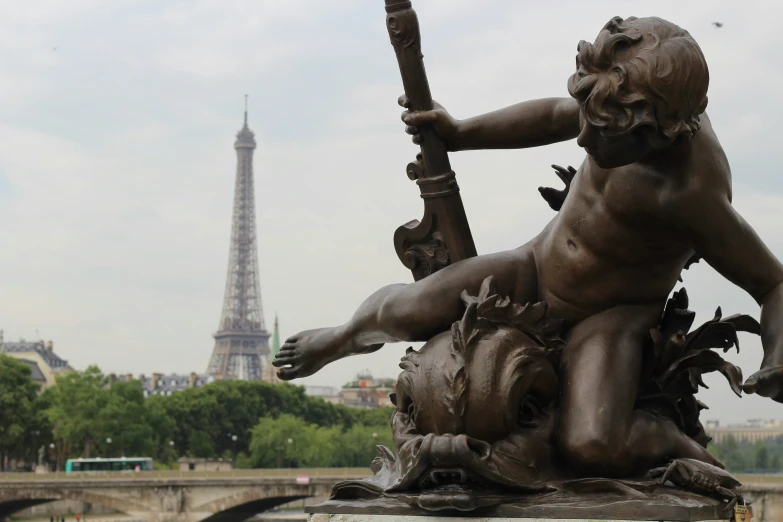 an angel statue with the eiffel tower in the background