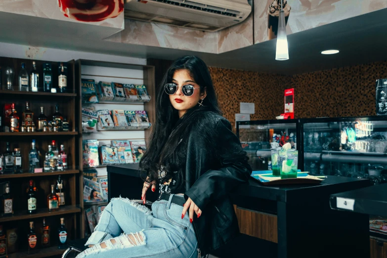 a woman sitting on the floor in front of shelves of cans and other objects