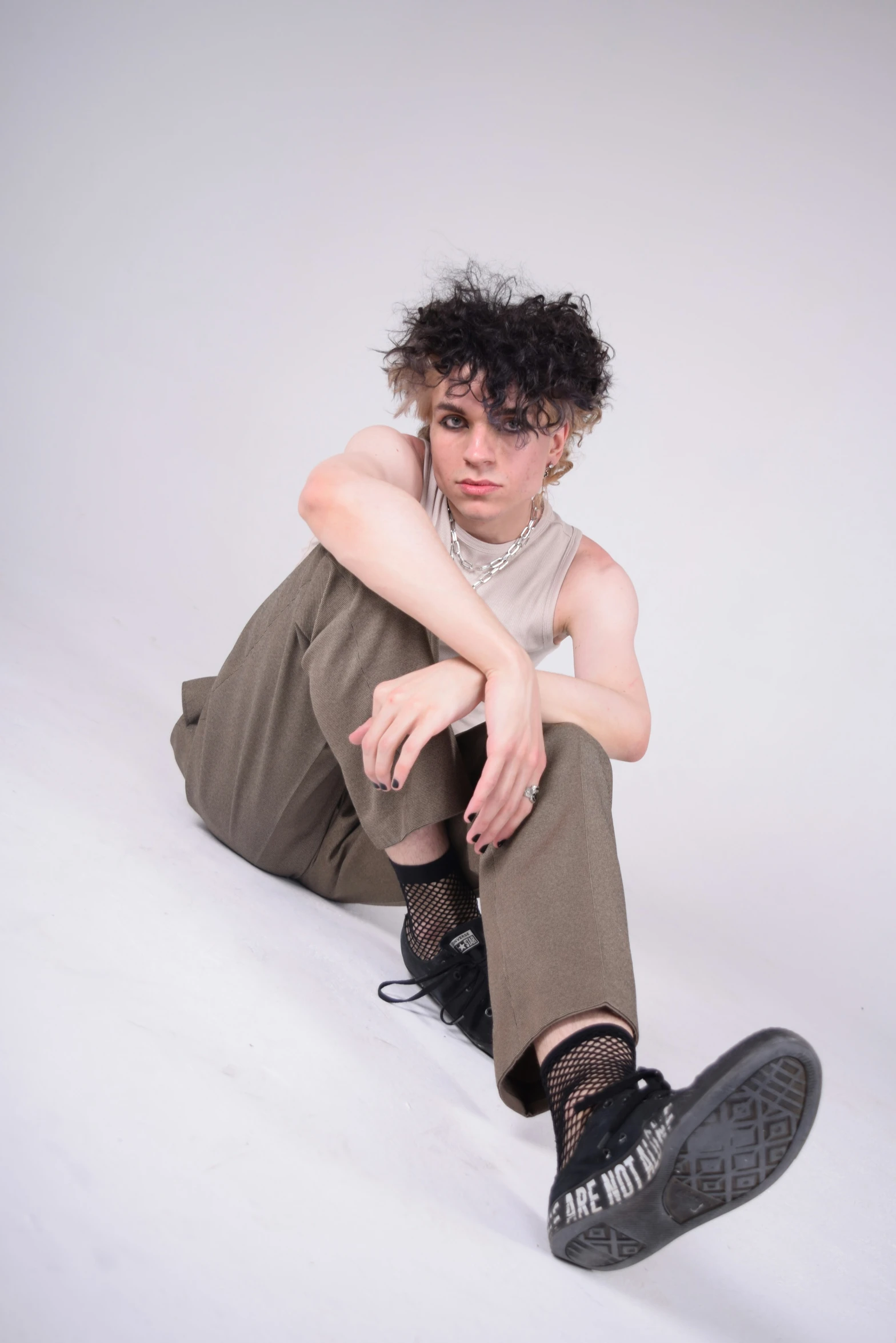 a man with curly hair sitting in the snow