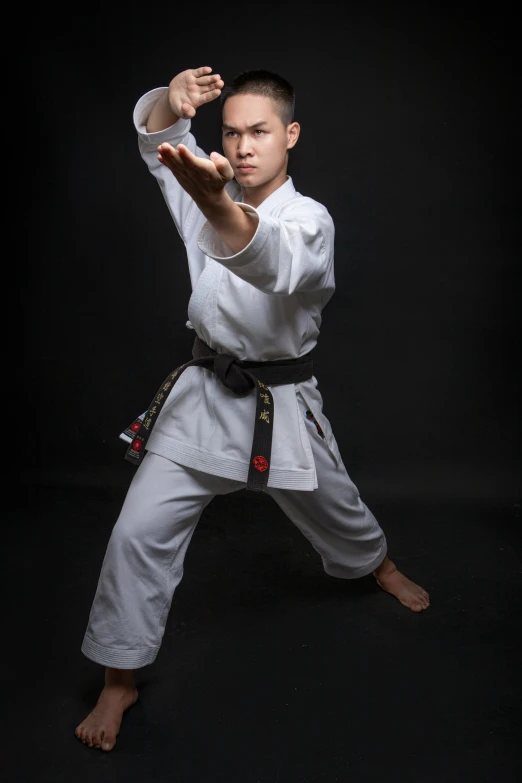 a man standing up on one foot while wearing a karate stance