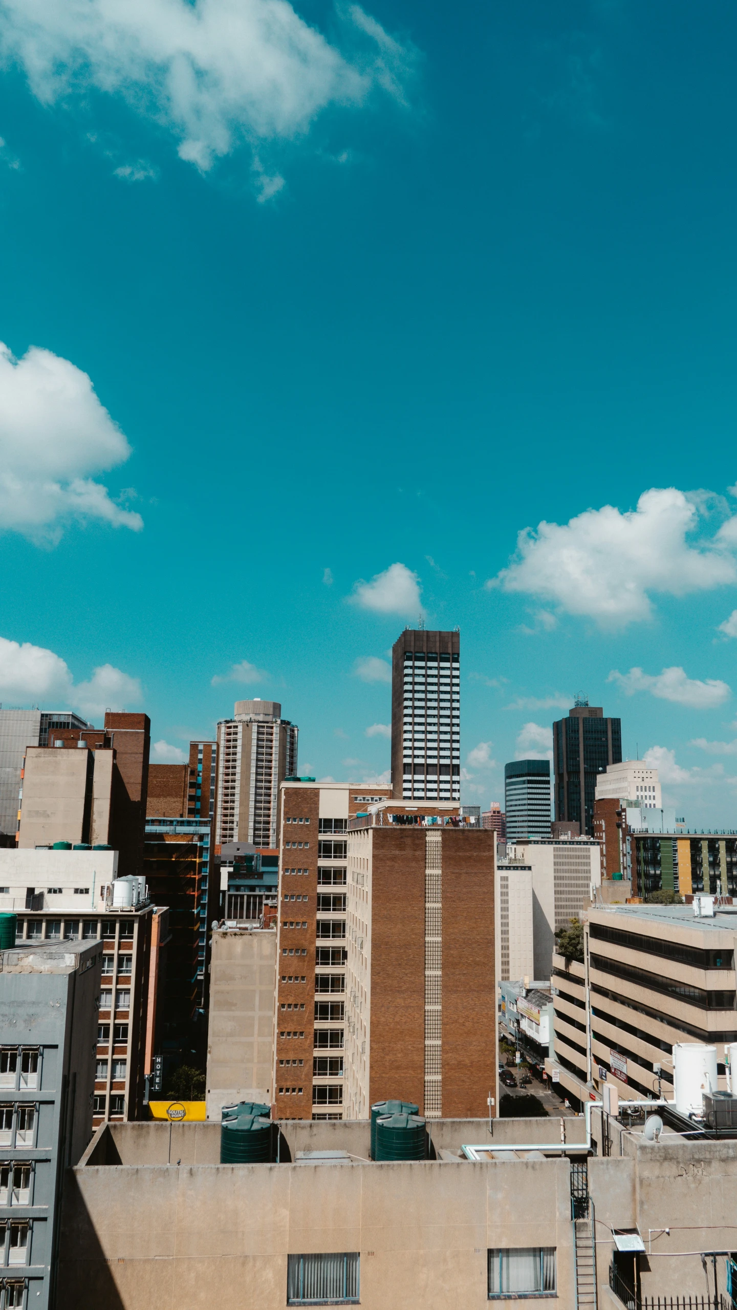 there are lots of tall buildings and cars parked on the roof of this building