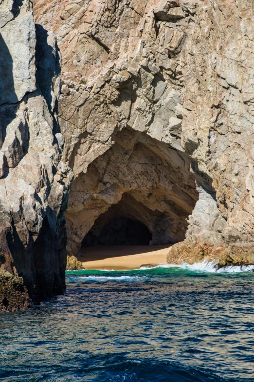 an ocean cave with a large opening in the cliffs