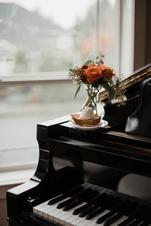 there is a small vase of flowers on a piano