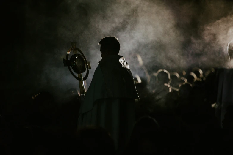 a person standing in front of a large crowd with their arm raised