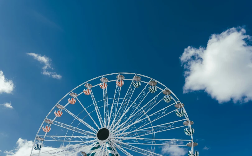 a large white ferris wheel in a blue sky