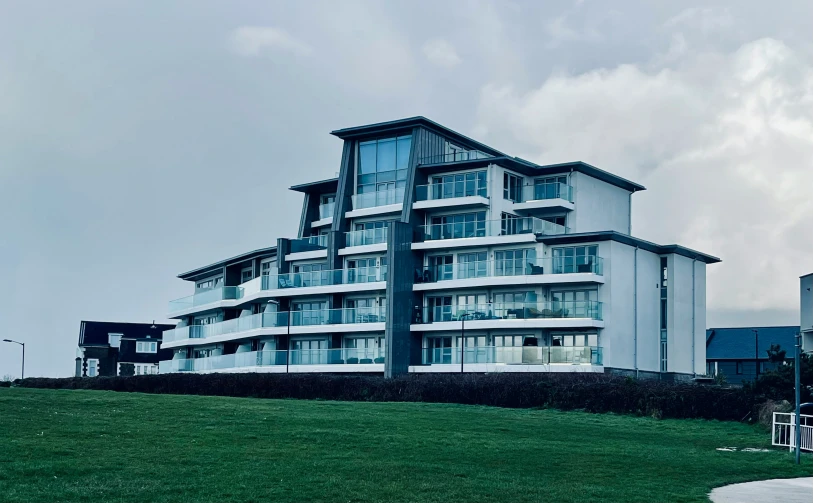 an apartment building with balconies and multiple balconies overlooking a green field