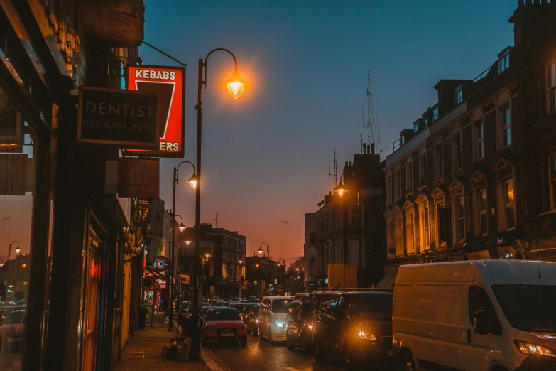 traffic travels down a city street at dusk