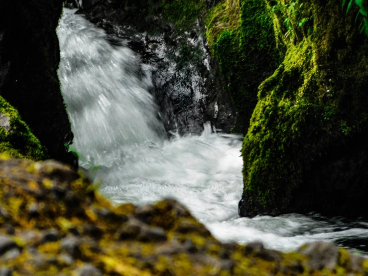 the water is rushing down a narrow stream