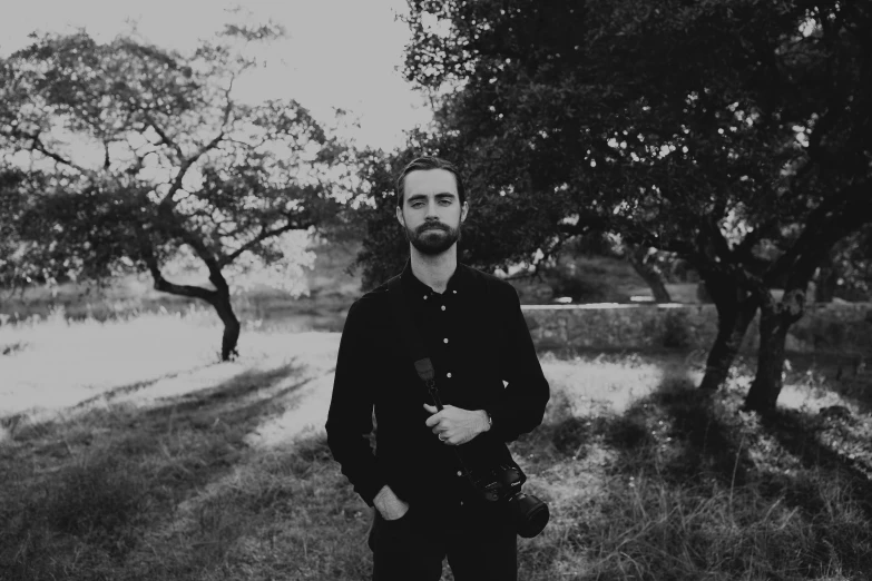 a man is standing next to some trees