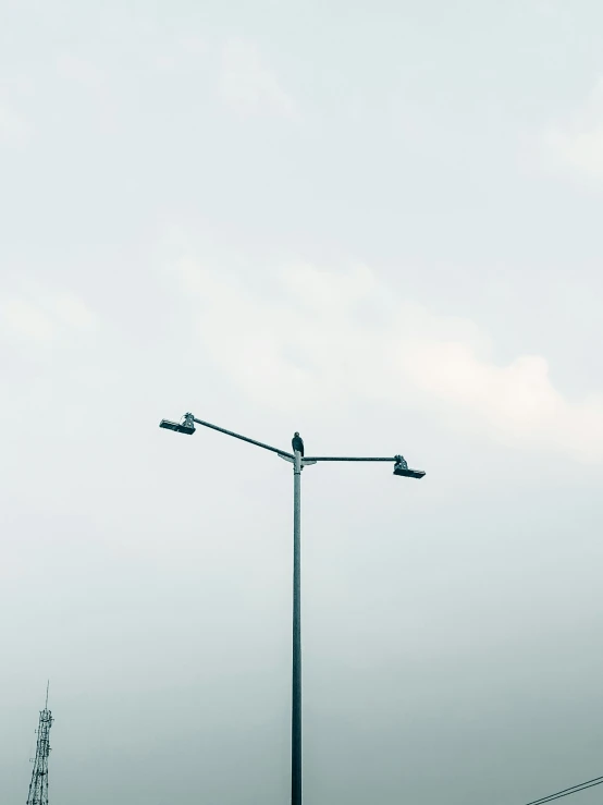 three street lamps stand on a metal post