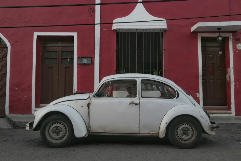 an old car is parked outside a building