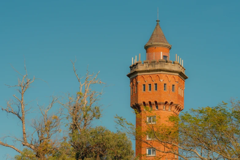 an old brick clock tower against a bright blue sky