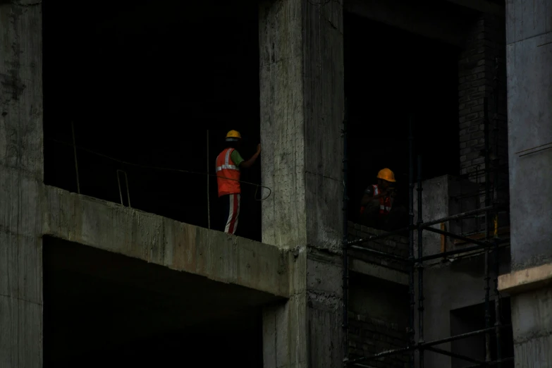 a group of workers standing on the side of a building under construction