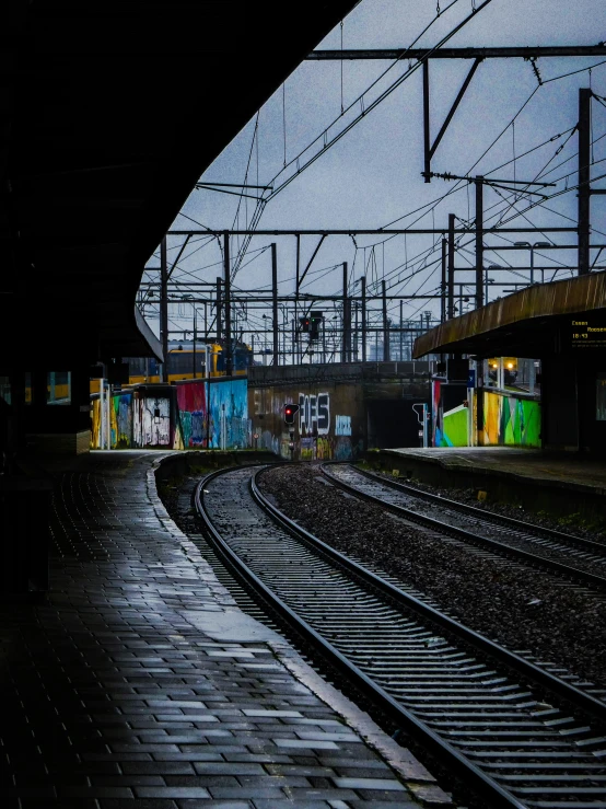 a train yard with multiple railroad tracks and graffiti on it