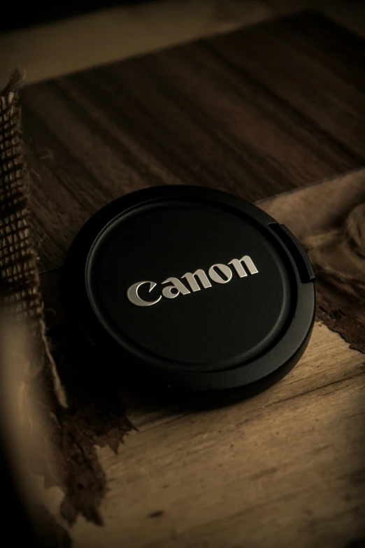 a camera cap that is on top of some wood