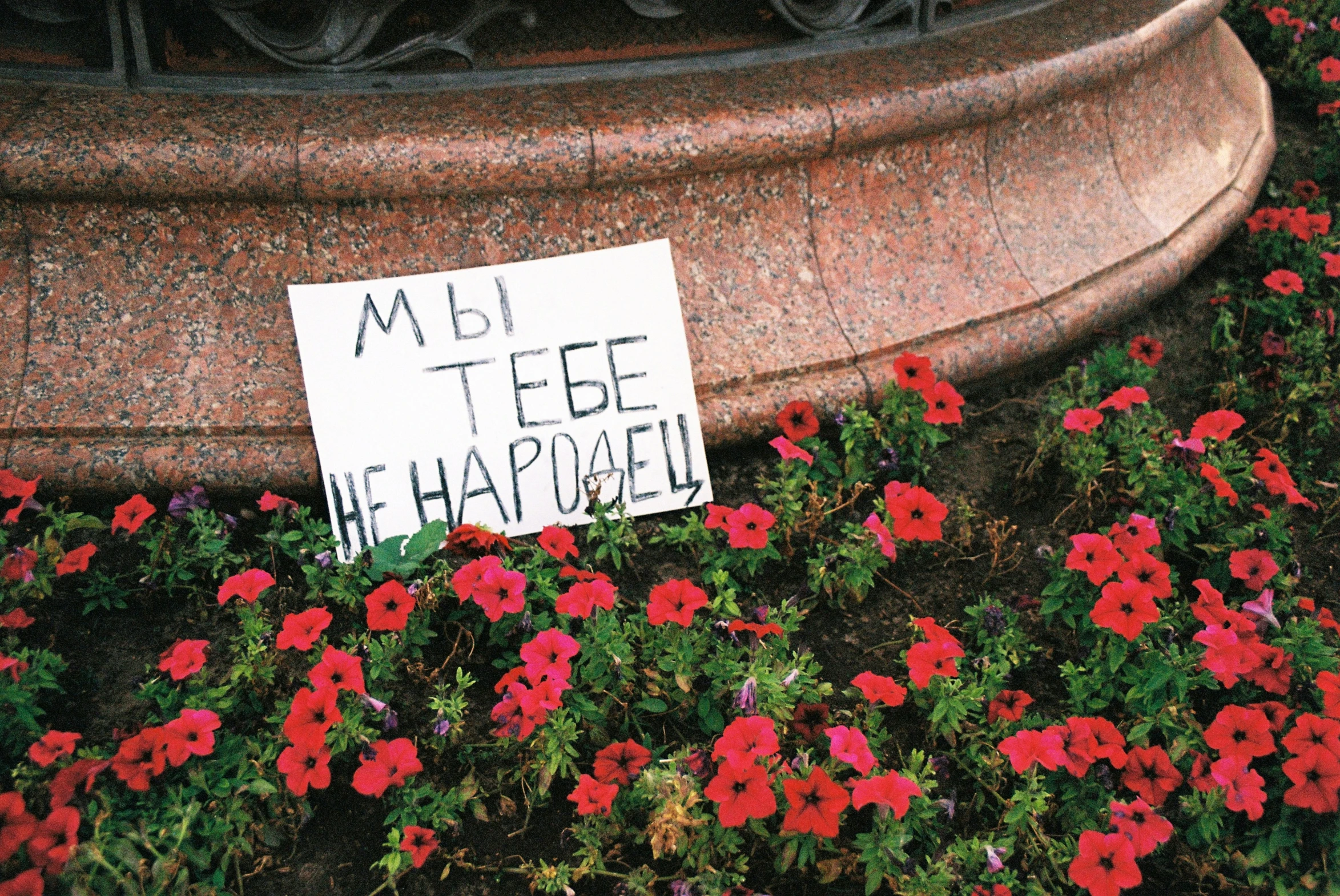 there is a sign on top of the flower bed