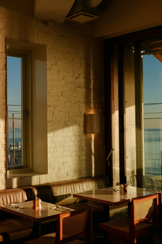 two tables with white tablecloths sit in a restaurant