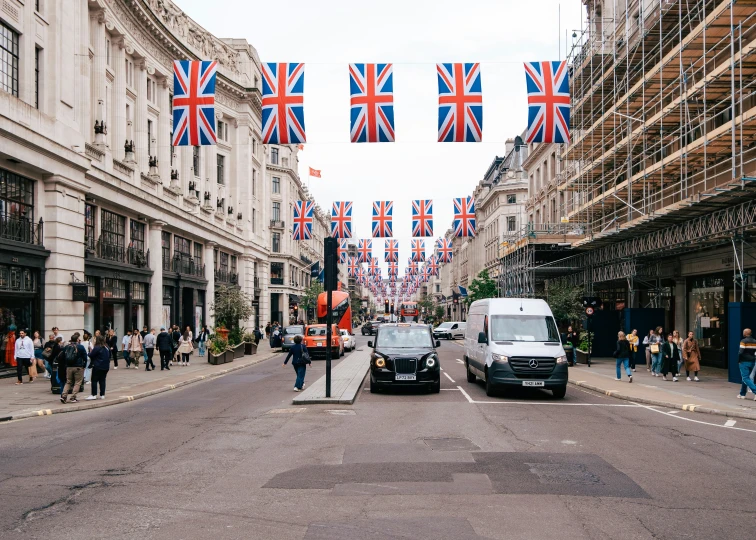 there are many flags in the air over the city street