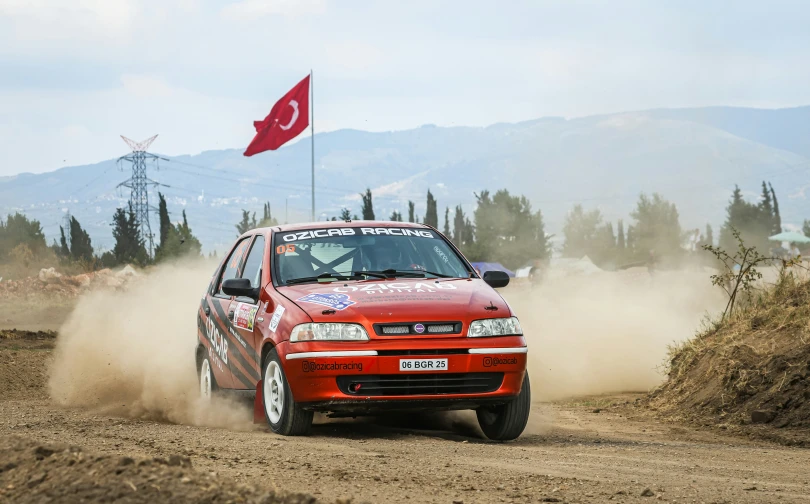 a car driving on dirt and a turkish flag