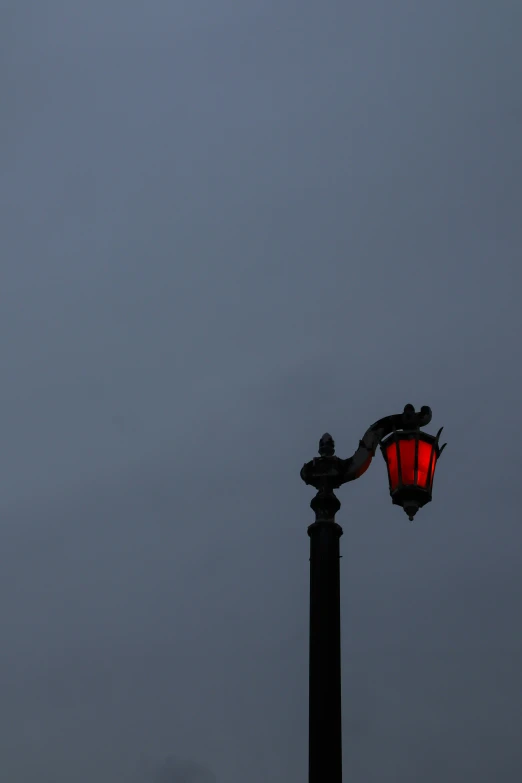 a street light and a lamp post against a gray sky