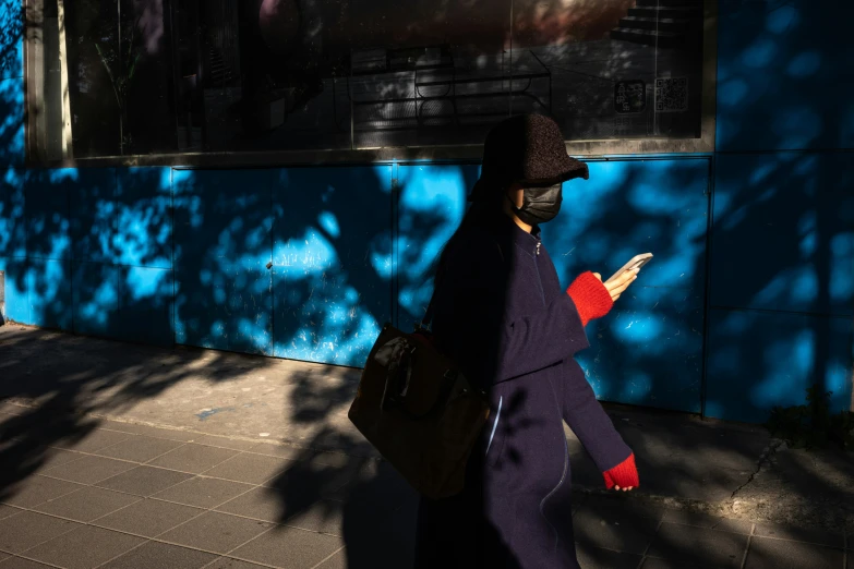 a person walking in front of a blue wall