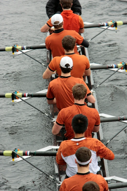 a long boat full of rowers on the water