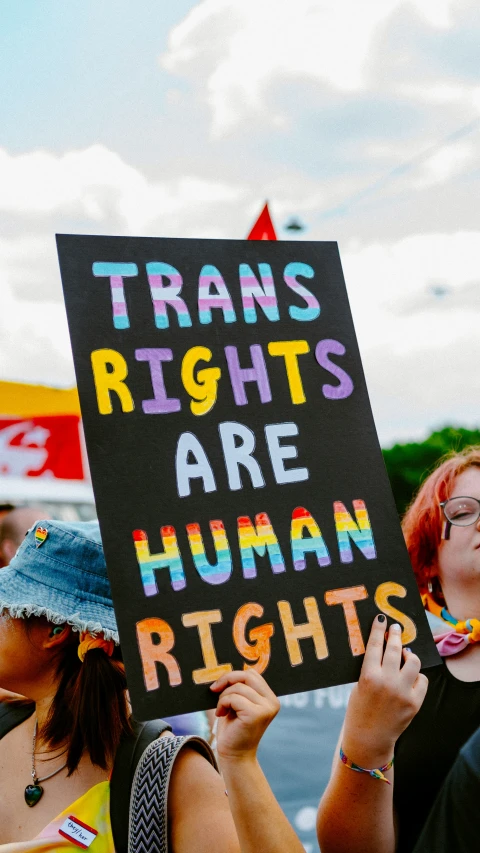 many people are holding up a sign that reads trans rights are human rights