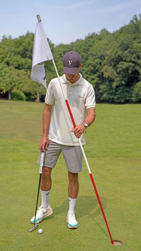 a young man holding a golf club and a flag