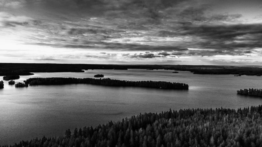 an aerial view of a large lake with many trees around it