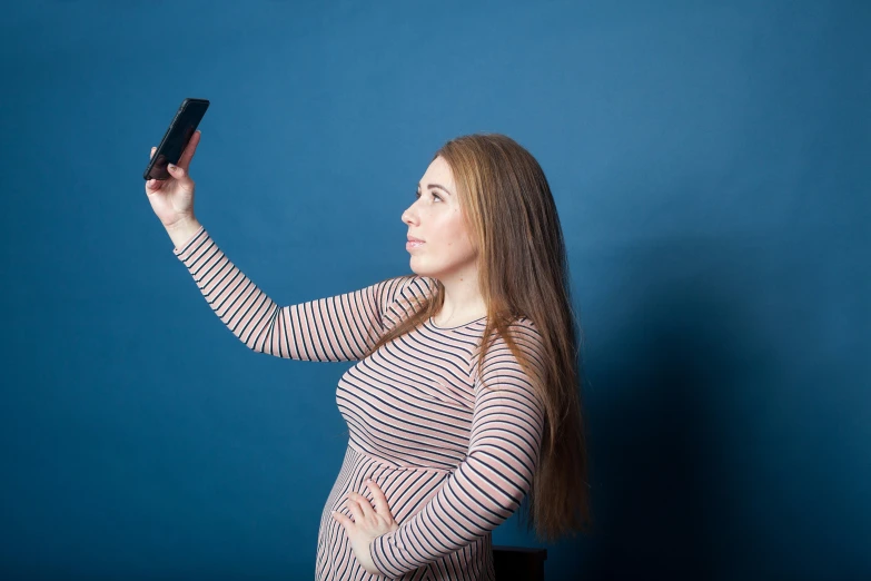 a woman is taking a po with her cell phone