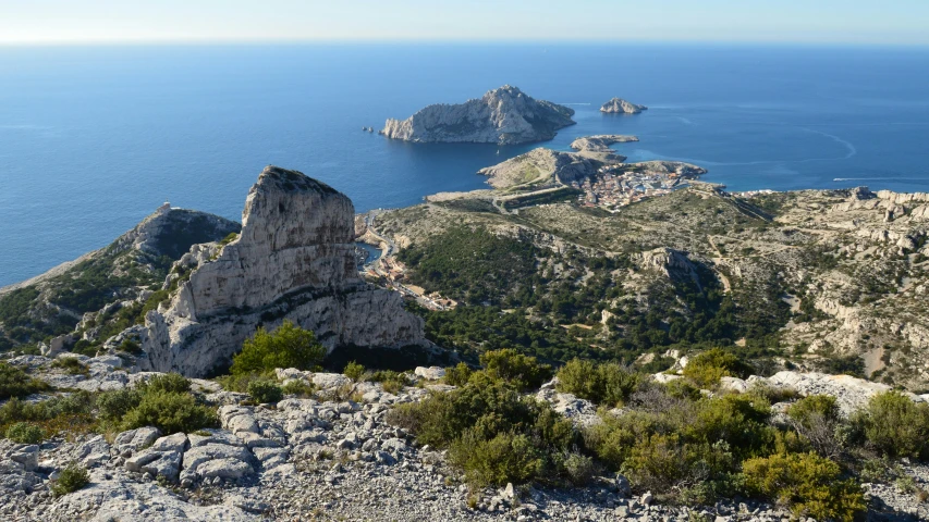 the ocean is next to the mountain in the daylight