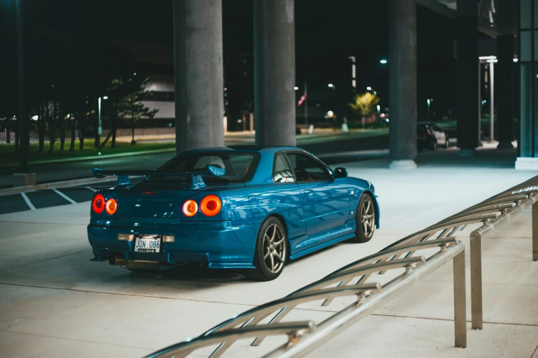 a blue car parked in front of some gray columns