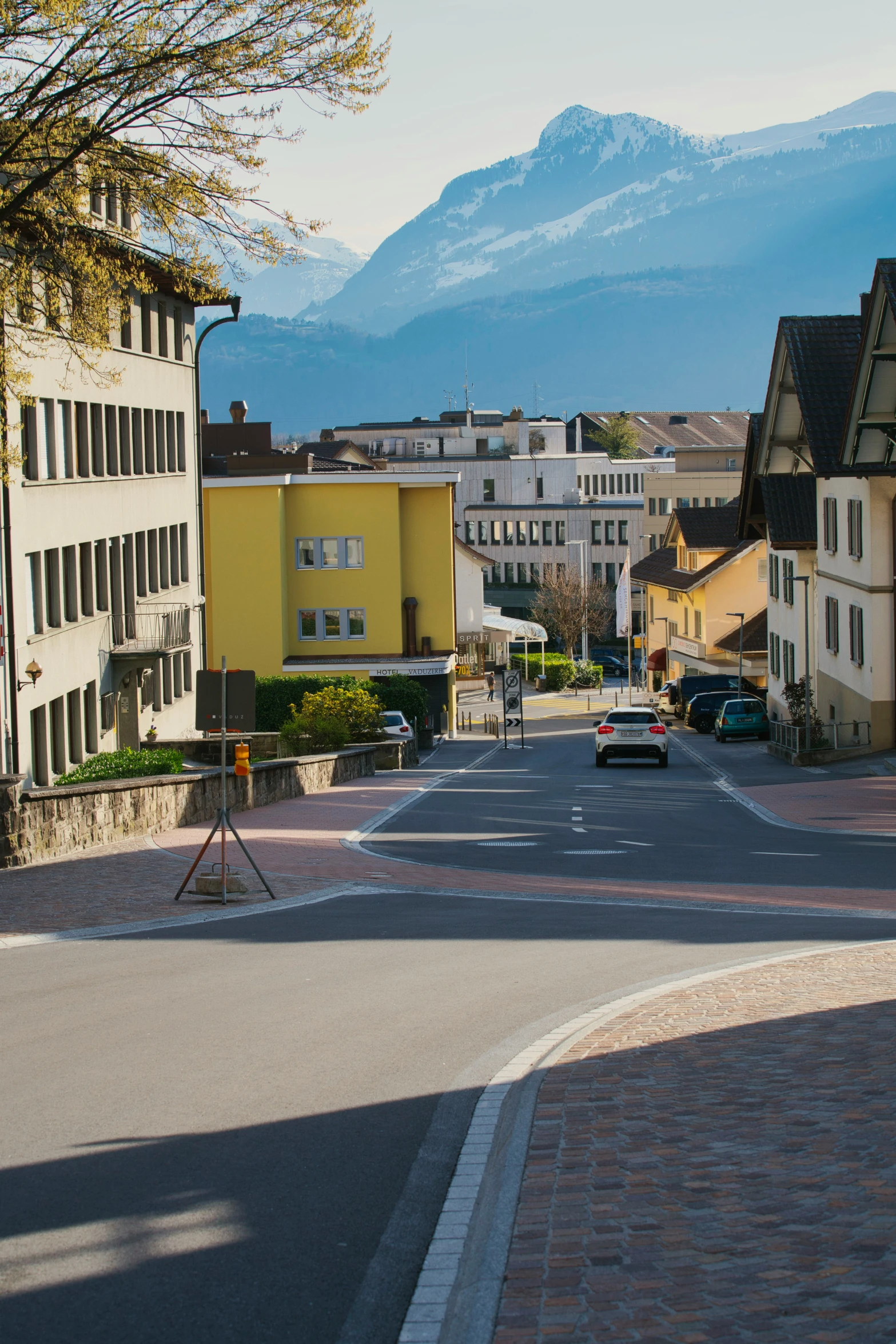 view down street with buildings and mountains in the background