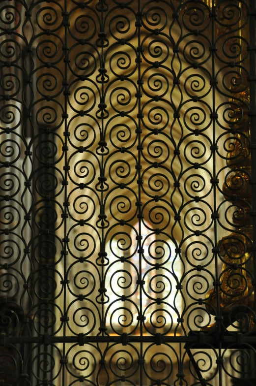a window with iron bars and intricate iron pattern