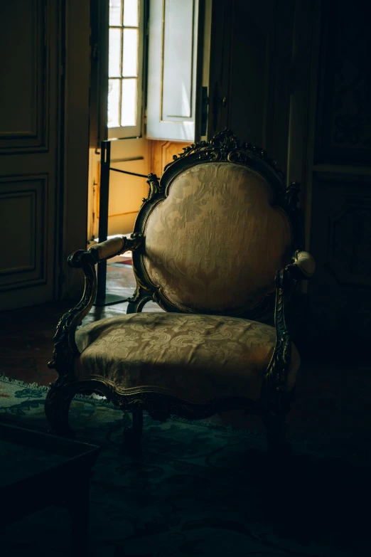 an old chair with no arms and arms rests in a room in the sun