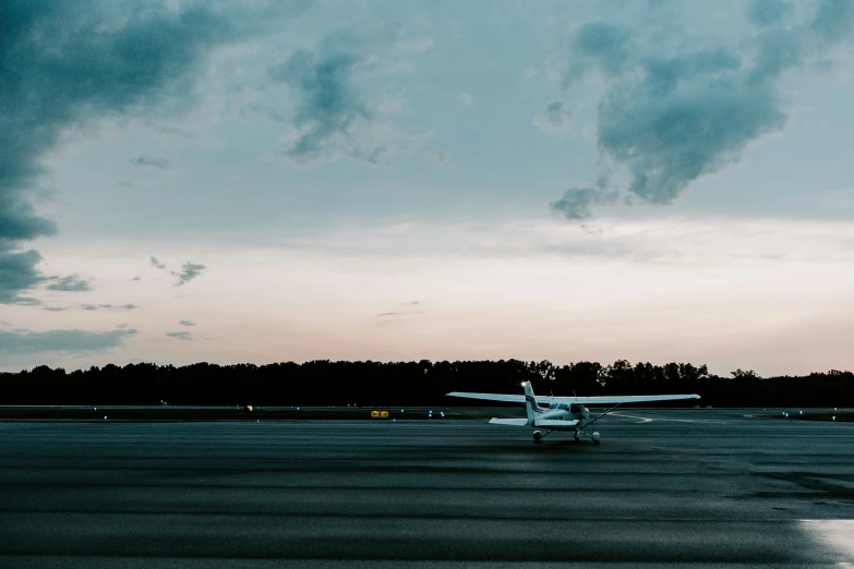 a plane on an airport tarmac under stormy skies